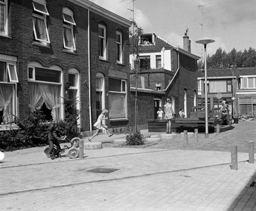 857239 Gezicht in de als leefstraat met plantenbakken en bankjes ingerichte Graanstraat te Utrecht, met enkele spelende ...